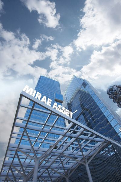 Glass skyscrapers under a blue sky, with a metal framework entrance bearing the sign 'MIRAE ASSET'
